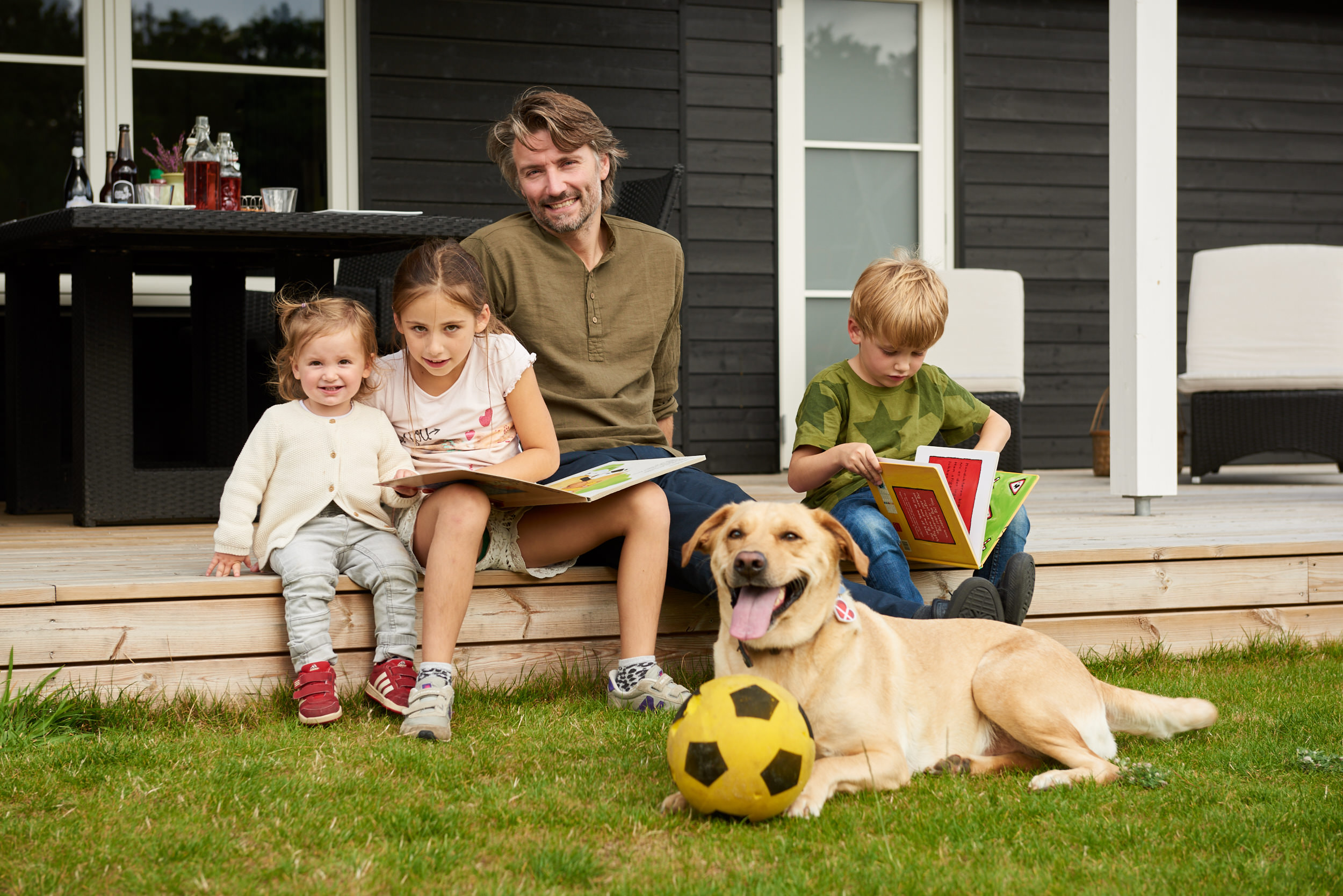 Far og børn hyggFar og børn feriehygger med hund ved sommerhus - fotografer med hund ved sommerhus - fotograf